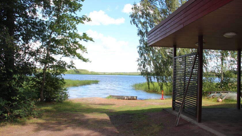 Hiekkainen ranta ja rakennuksen kulma.