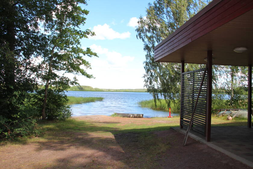 Hiekkainen ranta ja rakennuksen kulma.