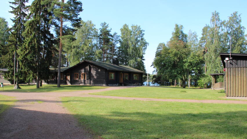 Hirsirakennuksia metsäisessä maisemassa.