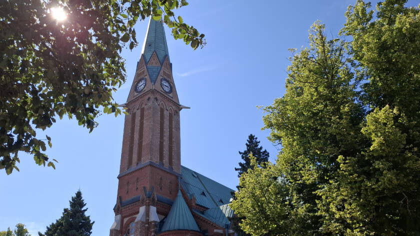 Kotkan kirkko, sininen taivas ja puita.